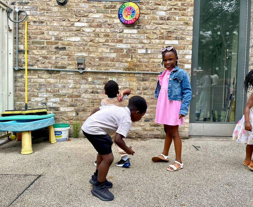 Young children playing together in the courtyard outside