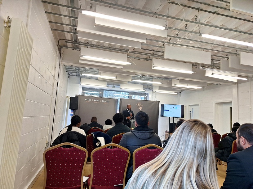 Pastor preaching from a lectern to a seated congregation in the church hall