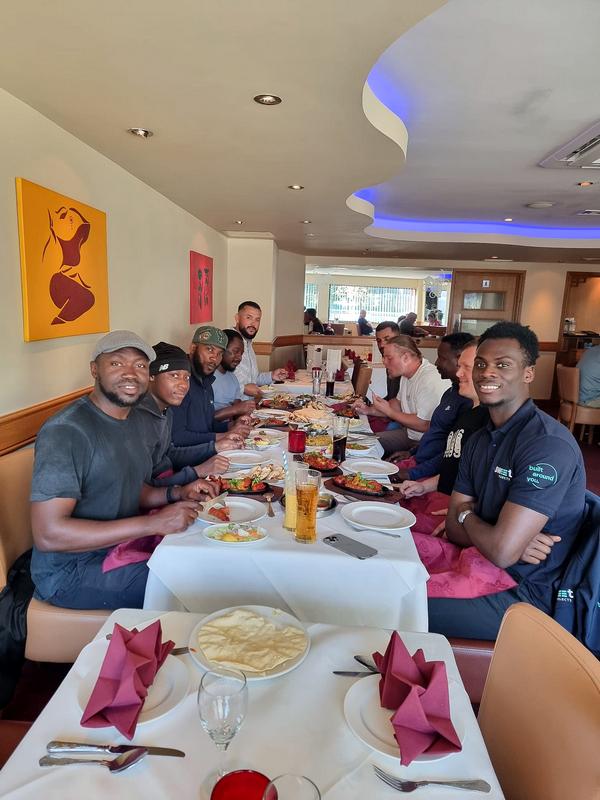 Church members sharing a meal together around a long restaurant table