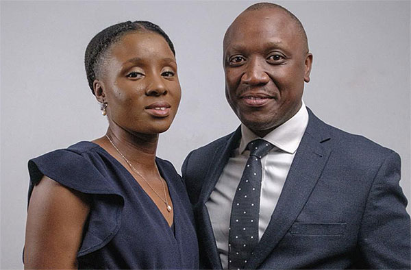 Pastor Julius and Gloria Igaba standing together in formal navy attire