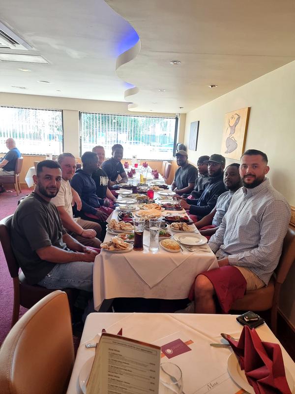 Church members smiling around a table at a fellowship meal